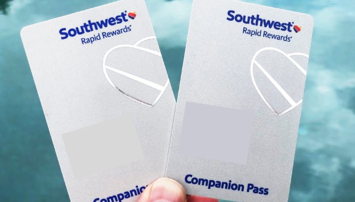 a hand holding two Southwest Airlines companion passes