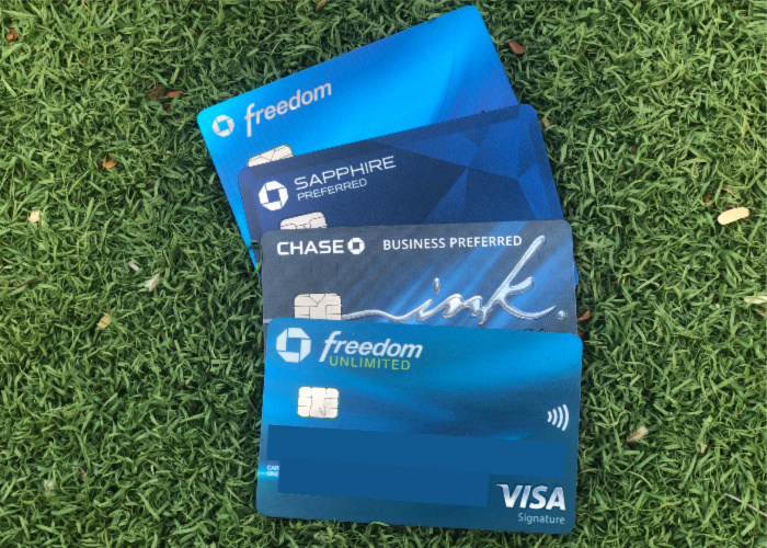 the Chase sapphire preferred, freedom, freedom unlimited and ink business preferred credit cards fanned out over a green background