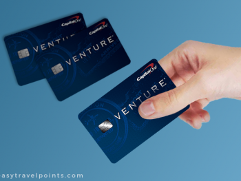 A hand holding a Capital One Venture credit card